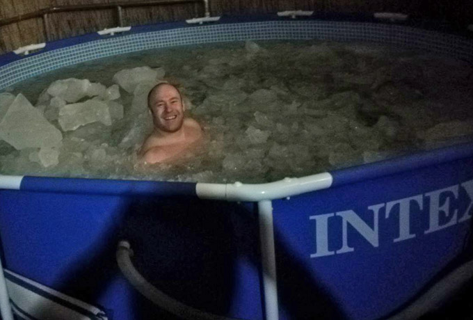 Mann in einem Pool voller Eisbrocken