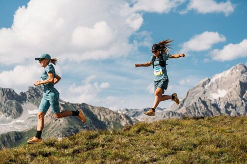 Zwei Trailrunner die mit großen Sprüngen einen Hand hinab laufen