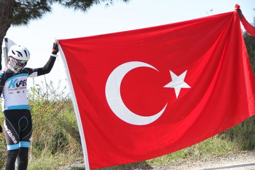 Radsportler, die eine rote türkische Fahne halten